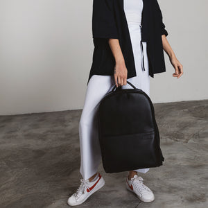 Monochrome outfit with black vegan leather camera backpack