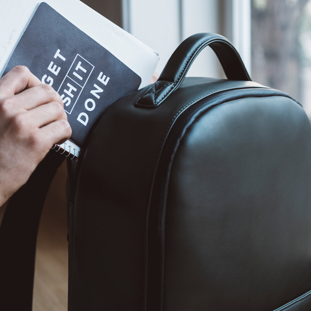 Putting notebook in laptop pocket in camera backpack